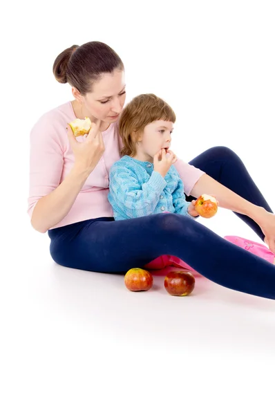 Madre con un bambino sedersi e mangiare mele — Foto Stock