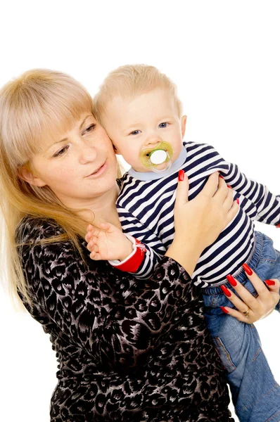 Mamma hålla glada lilla bebis i famnen, suger napp Stockfoto