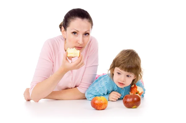 Madre con un niño miente y come manzanas Fotos De Stock Sin Royalties Gratis