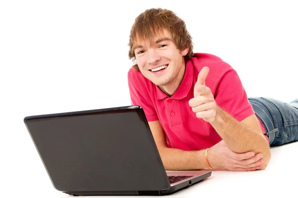 The beautiful guy works for laptop and points to you — Stockfoto