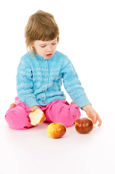 Het kleine meisje eet een appel — Stockfoto