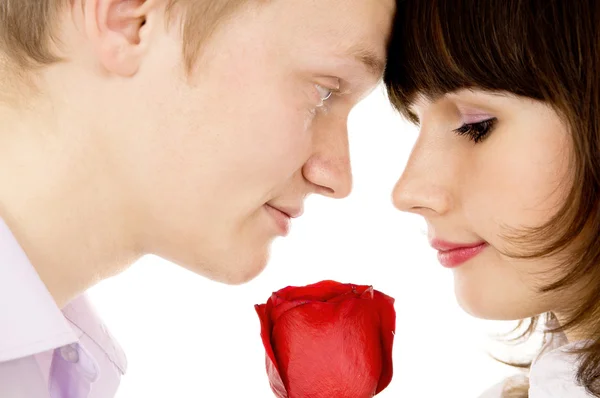 Um cara e uma menina segurando uma rosa e olhar um para o outro — Fotografia de Stock