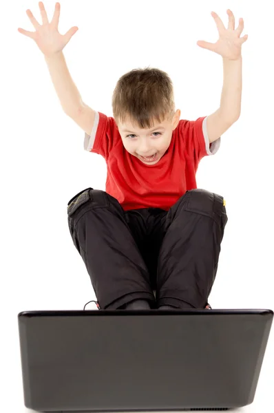 Un bambino piccolo felicemente guardando nel computer notebook, sollevare — Foto Stock