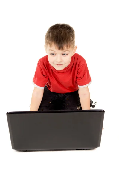 Маленький ребенок заглядывает в ноутбук — стоковое фото