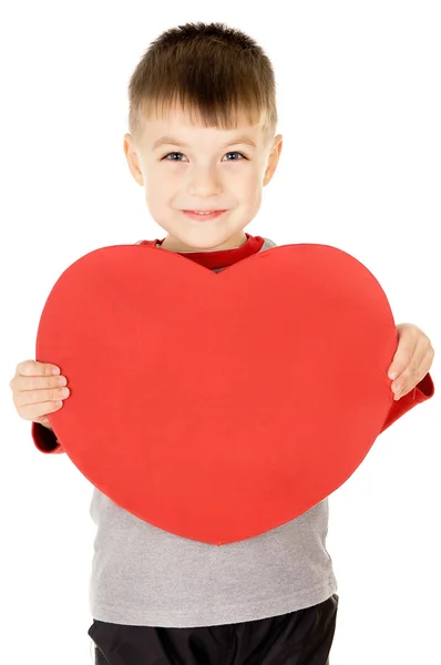 A small child stands and holds the heart — Stock Photo, Image