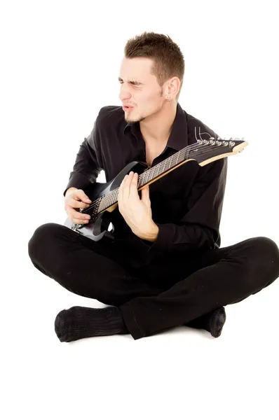 Beautiful guy dressed in black clothes sings and plays the guita — Stock Photo, Image