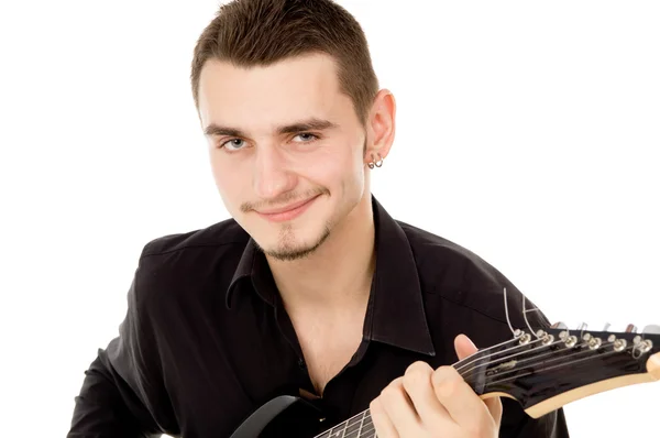 Szép srác öltözött fekete ruhában ül és játszik a gitár — Stock Fotó