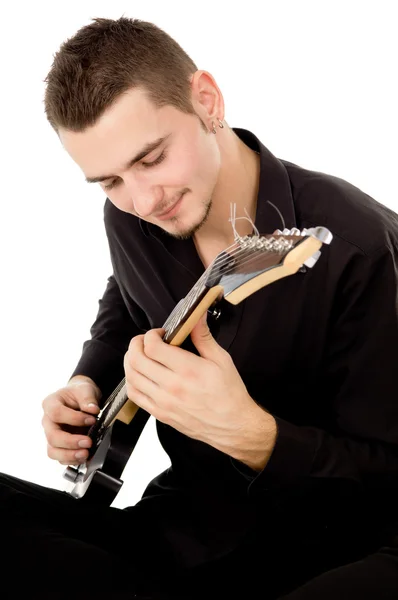 Tipo vestido con ropa negra se sienta y toca la guitarra — Foto de Stock