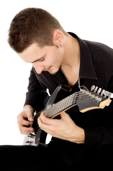 Guy dressed in black clothes sits and plays the guitar — Stock Photo, Image