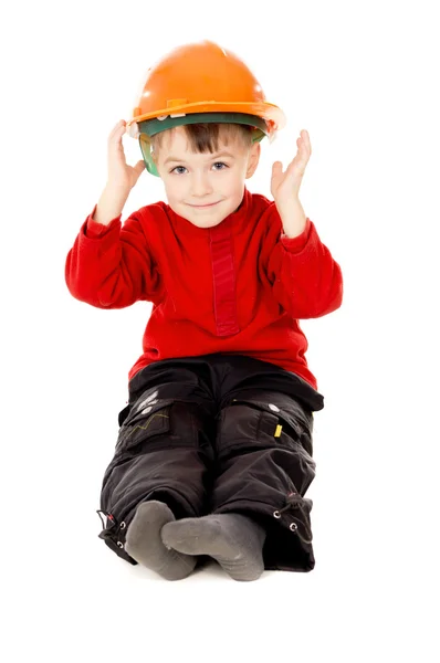 Menino feliz senta-se com um capacete — Fotografia de Stock