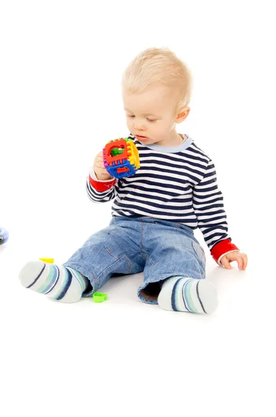 A little kid playing with a toy Stock Image