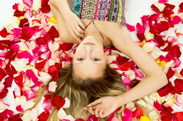 Beautiful girl lying with rose petals — Stock Photo, Image