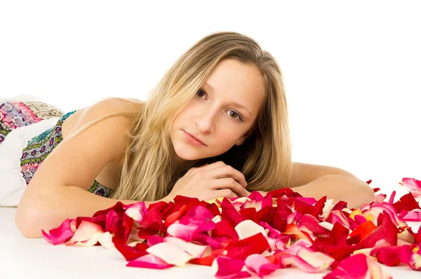 Блондинка лежит с лепестками роз — стоковое фото