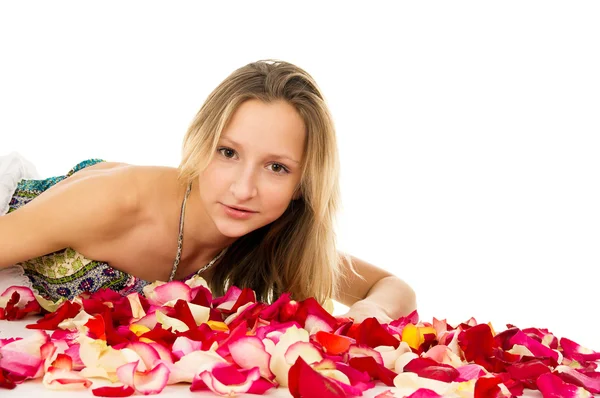 Retrato de uma linda menina deitada em pétalas de rosa — Fotografia de Stock