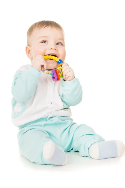 Uma criança pequena segurando um brinquedo em sua boca — Fotografia de Stock
