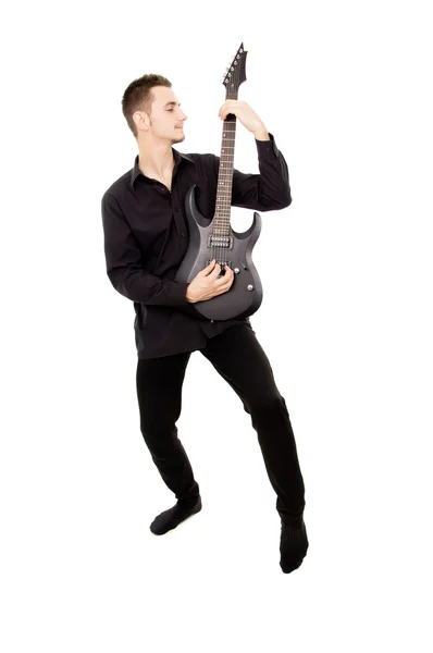 A young guy in black clothes plays the guitar — Stock Photo, Image