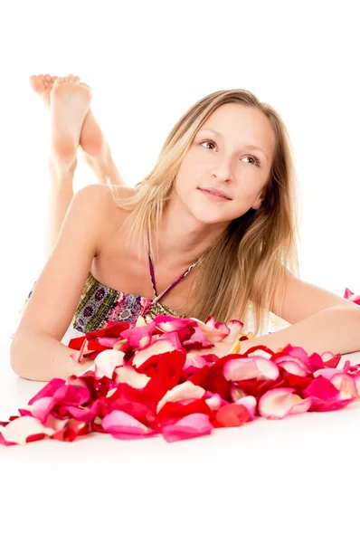 Menina bonita encontra-se em pétalas de rosa — Fotografia de Stock