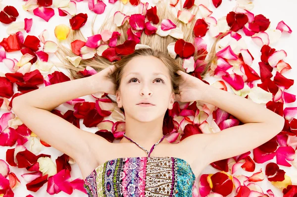 Menina bonita encontra-se nas pétalas de rosas — Fotografia de Stock