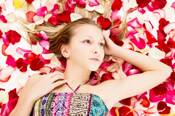 Menina bonita encontra-se nas pétalas de rosas — Fotografia de Stock