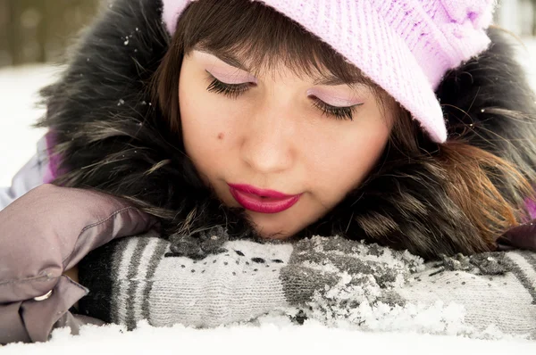 Mooi meisje liggen in de sneeuw — Stockfoto