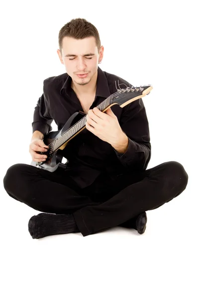 Beautiful guy dressed in black clothes sings and plays the guita — Stock Photo, Image