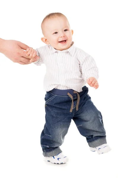 Веселый мальчик в одежде делает первые шаги — стоковое фото
