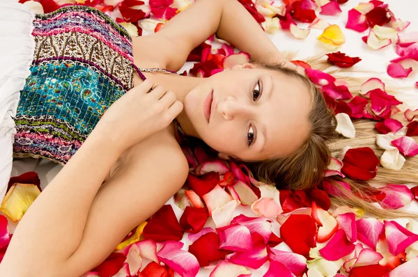 Girl lies in the petals of roses — Stock Photo, Image