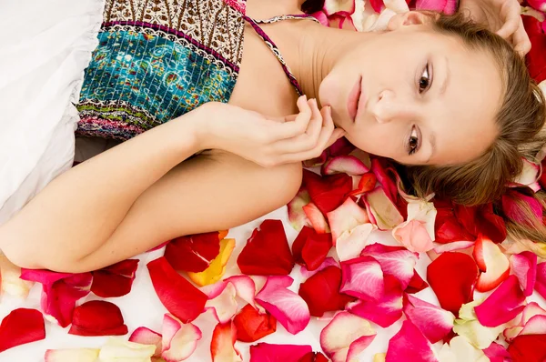 Menina encontra-se nas pétalas de rosas — Fotografia de Stock