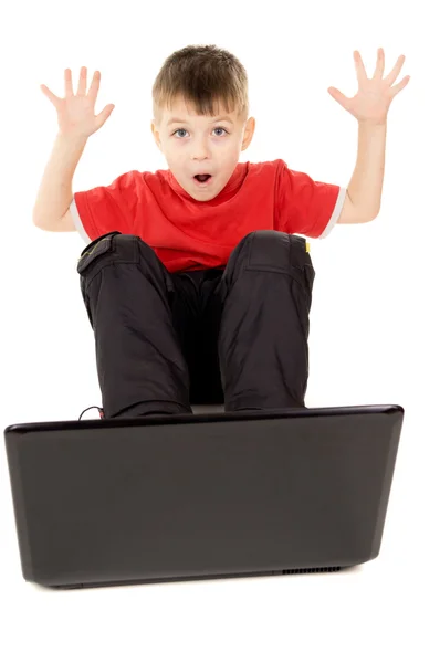 Un niño pequeño felizmente mirando en la computadora portátil, criar — Foto de Stock