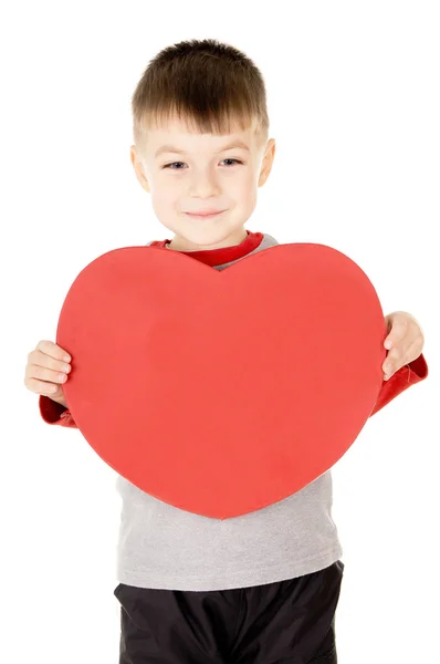 A small child stands and holds the heart — Stock Photo, Image