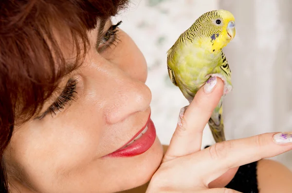 In age woman with a parrot — Stock Photo, Image