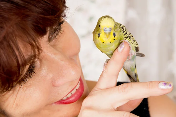 In age woman with a parrot — Stock Photo, Image