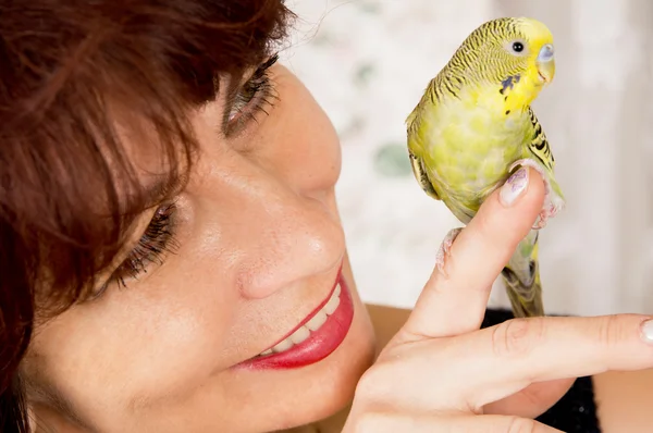 In age woman with a parrot — Stock Photo, Image
