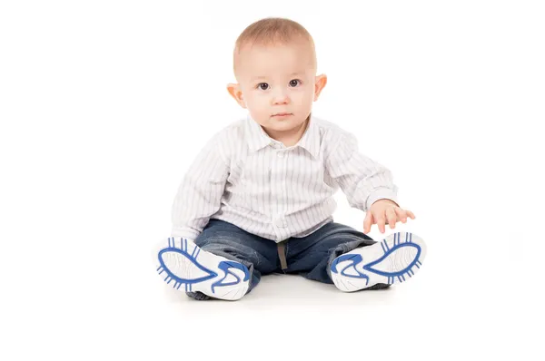 Ребенок в одежде сидит на полу — стоковое фото