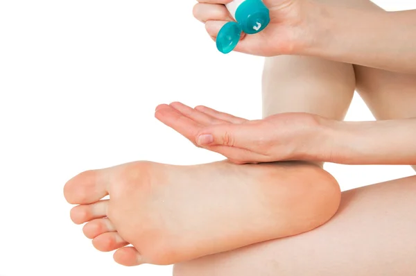 Girl rubs cream heel, feet — Stock Photo, Image