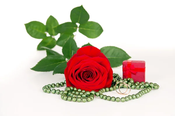 Rose with gift and wedding rings and beads — Stock Photo, Image