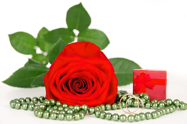 Rose with wedding rings and beads — Stock Photo, Image