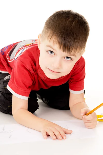 Een kleine jongen trekt op het papier — Stockfoto