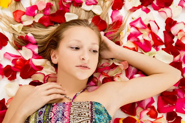 Menina encontra-se nas pétalas de rosas — Fotografia de Stock