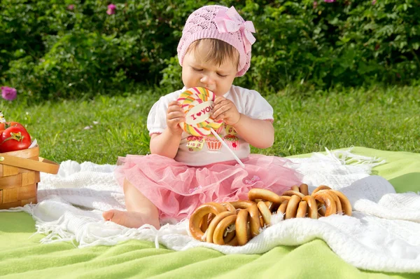 Doğada bir piknik üzerinde oturan bebek — Stok fotoğraf