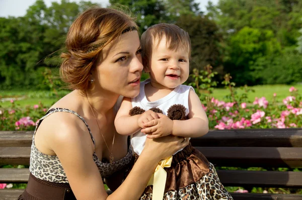 Mère heureuse avec un bébé sur un banc de repos — Photo