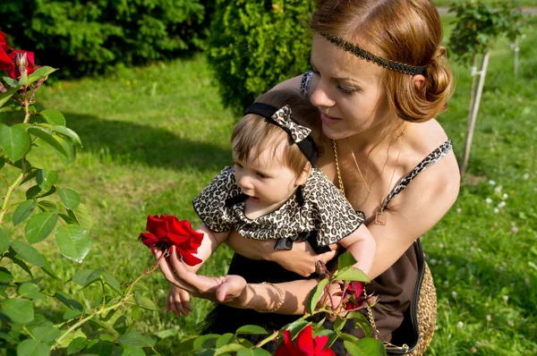 Mãe mostra criança flor — Fotografia de Stock