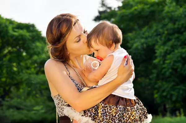 Mamá besa al bebé en la naturaleza —  Fotos de Stock