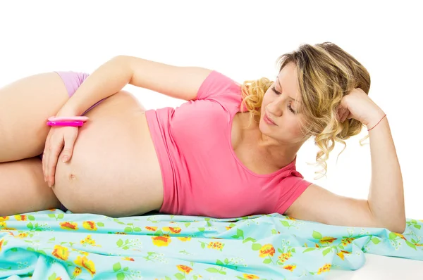 Beautiful pregnant woman lying on the fabric and reflects — Stock Photo, Image