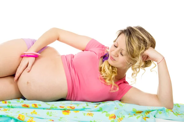 Schöne schwangere Frau auf dem Stoff liegend — Stockfoto