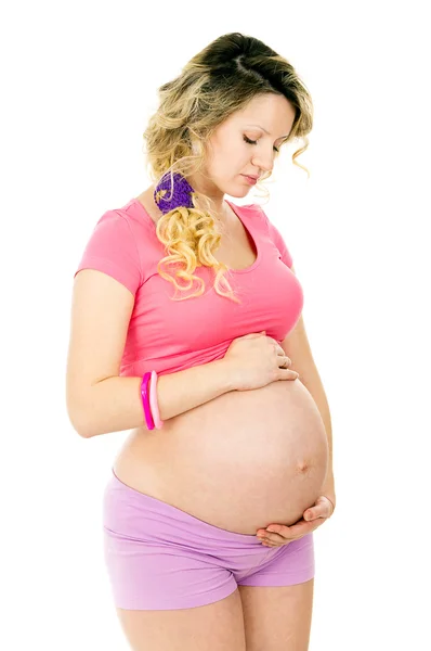 Беременная девушка обнимает живот — стоковое фото