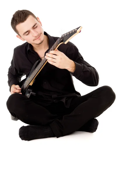 Dark-haired beautiful guy plays the electric guitar — Stock Photo, Image