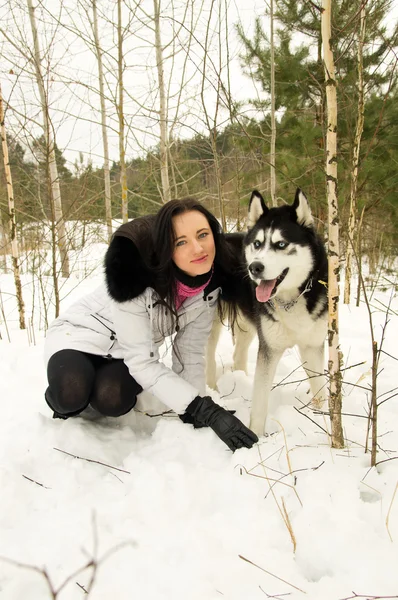Flicka och siberian husky i vinter — Stockfoto