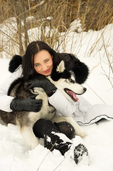 Tjej leker med en hund i skogen — Stockfoto