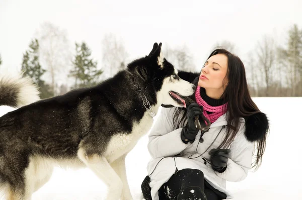 Jeune fille avec un chien en hiver — Photo